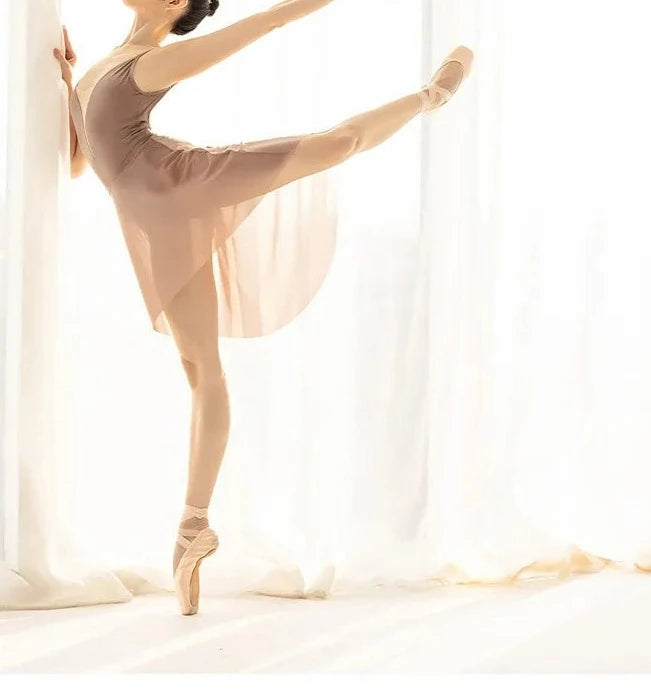 Women in an arabesque ballet pose wearing a mesh beige ballet skirt
