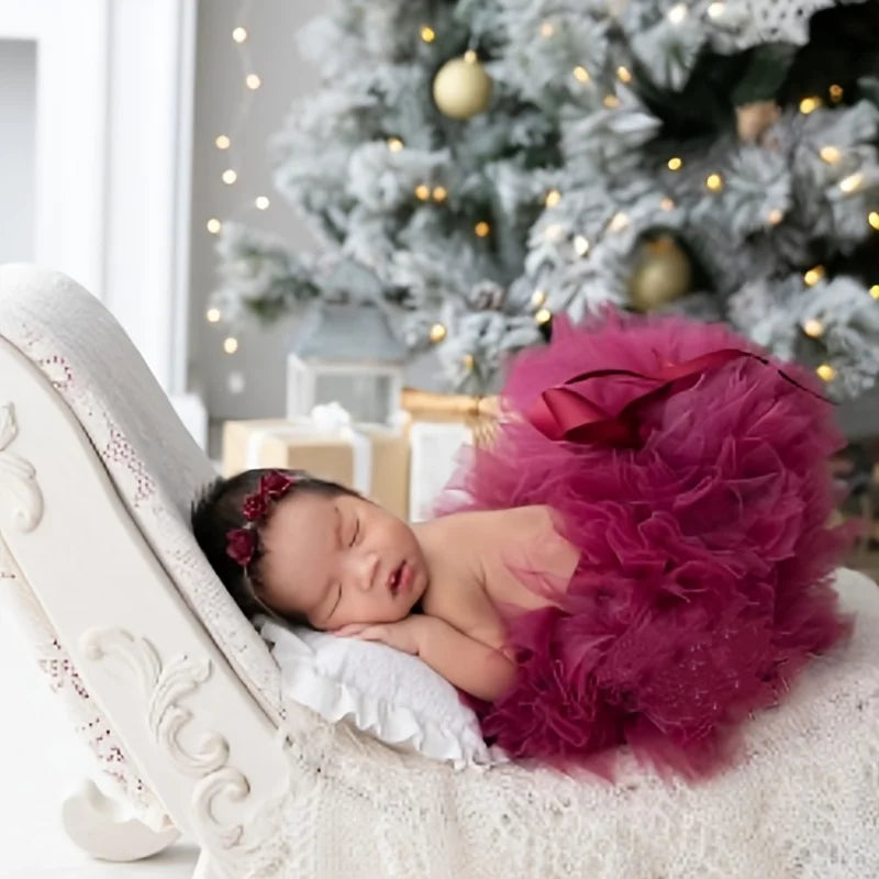 baby wearing a burgundy tutu and headband