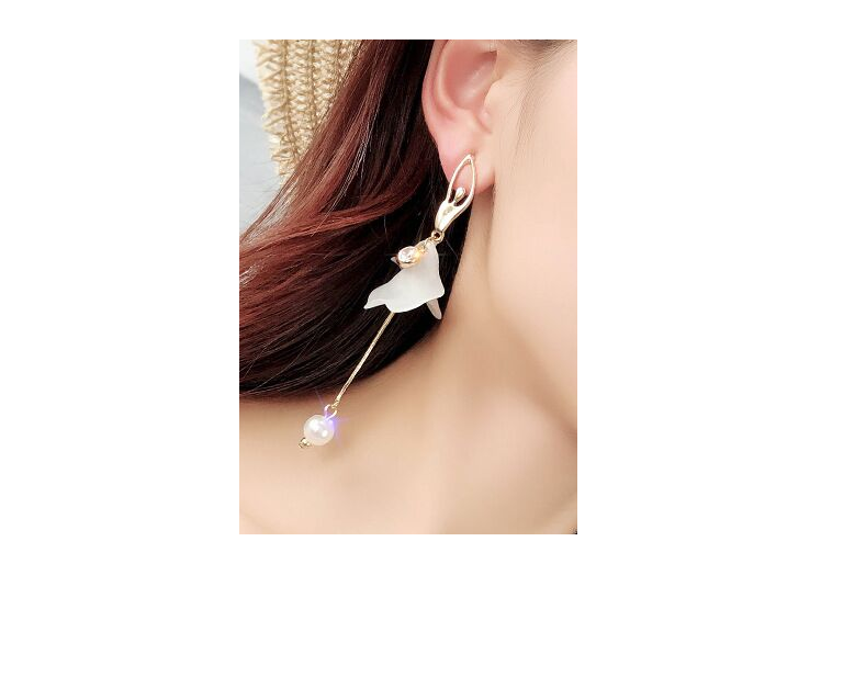 woman wearing gold tone and white ballerina dangle earrings