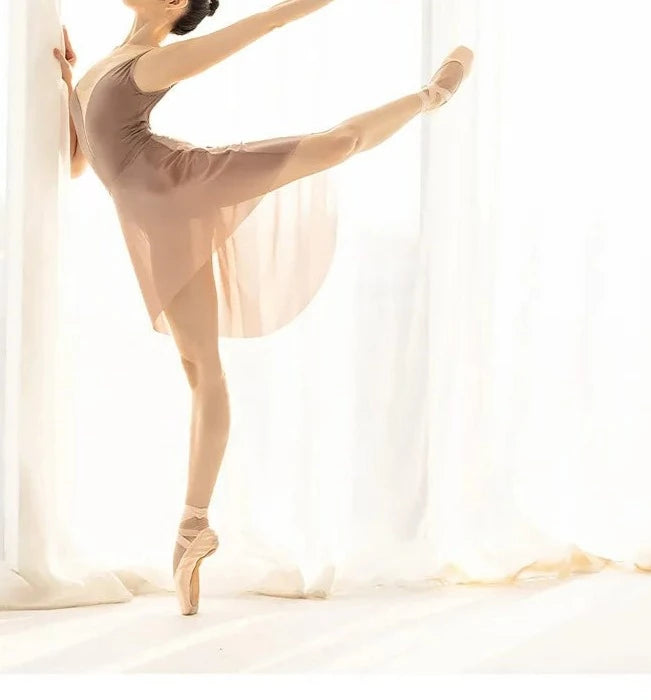 Mulheres em uma pose de balé arabesco usando uma saia de balé bege