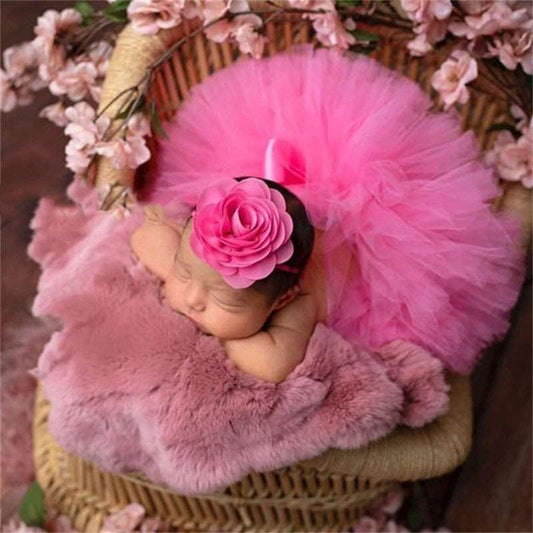 bebê vestindo um tutu de balé rosa com faixa na cabeça combinando