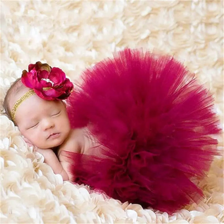 Das Baby trägt ein kastanienbraunes Tutu mit einem passenden kastanienbraunen Blumenstirnband