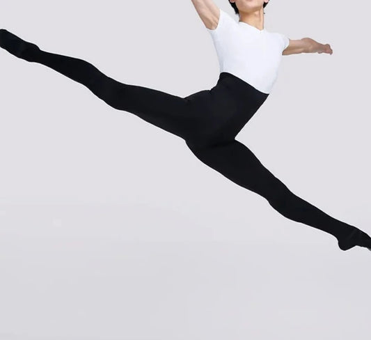 Bailarín de ballet masculino learping vistiendo un mono blanco y negro