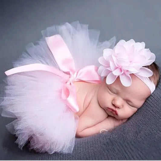 bebê usando tutu de balé rosa com faixa de flores