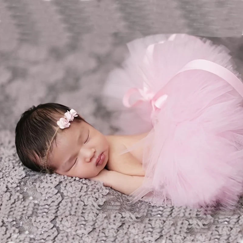 un recién nacido con un tutú rosa y una diadema