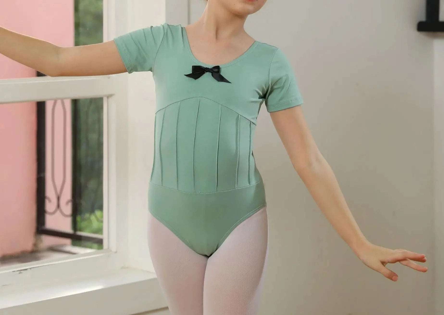 front of green girl's short sleeved leotard with black bow on front