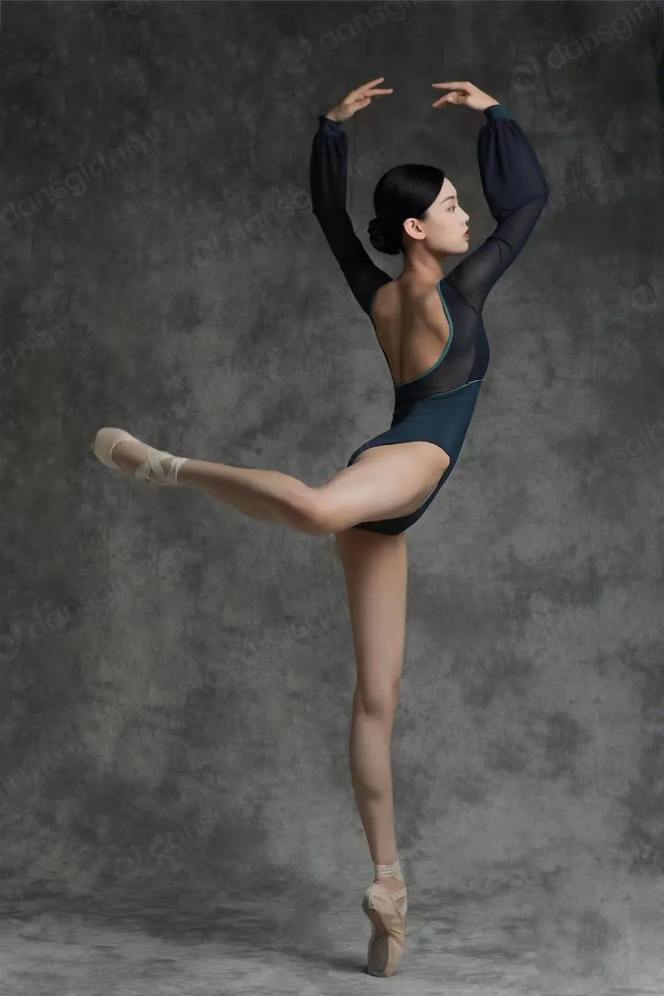 Balletttänzerin trägt einen schwarzen Trikotanzug und macht eine Arabeskenpose