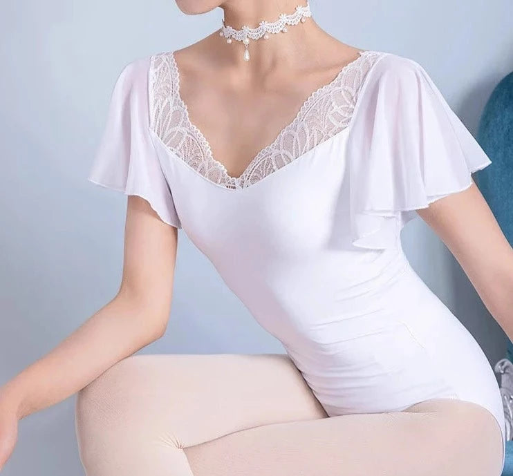 frente de una mujer que llevaba un leotardo de ballet blanco con mangas onduladas
