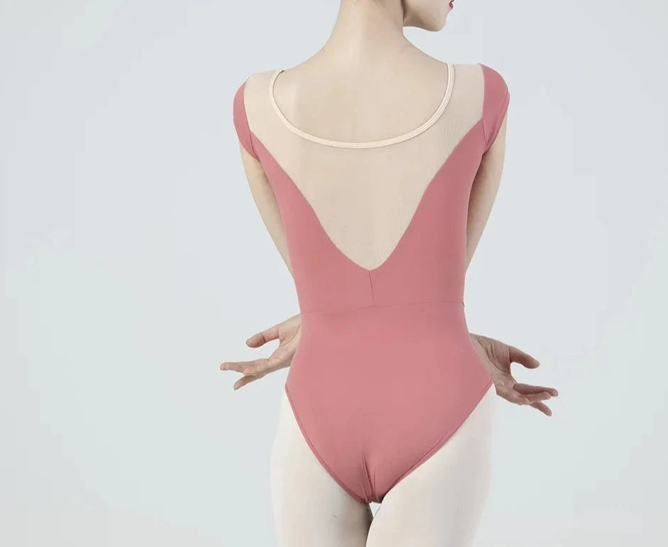 Parte posterior de una bailarina de ballet vistiendo un leotardo de manga corta de color salmón.