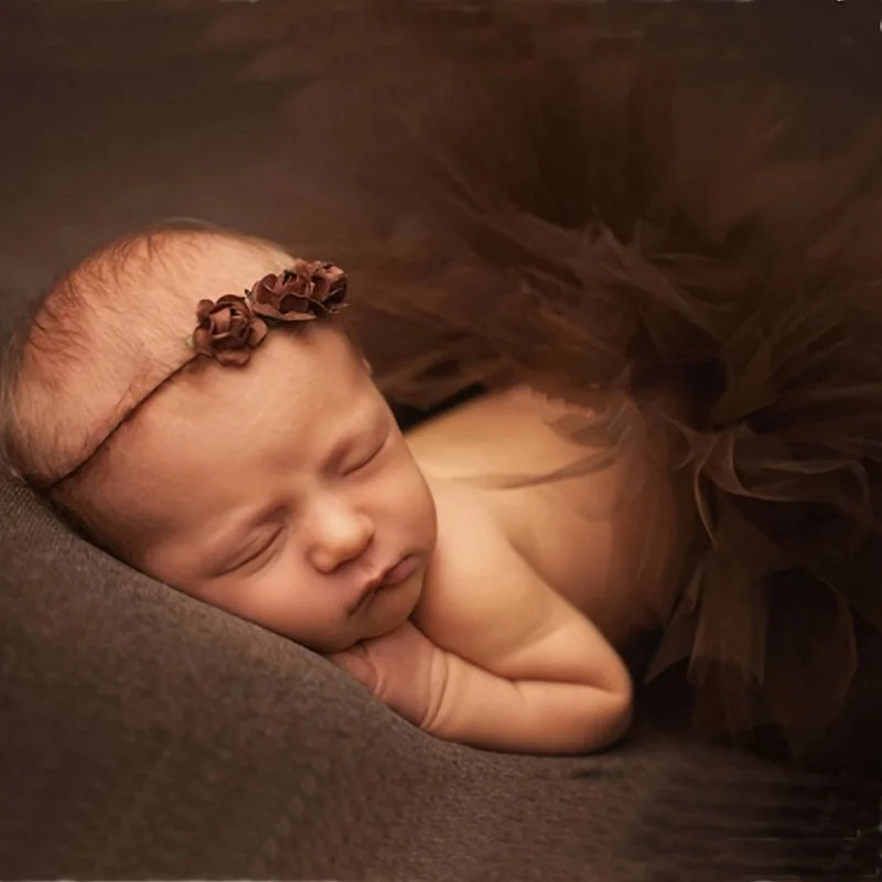 bebé con un tutú marrón y una diadema