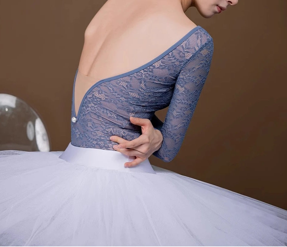 Rücken einer Balletttänzerin, die einen grauen, langärmligen Spitzentrikot trägt
