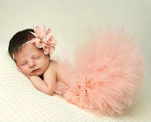bebê vestindo tutu rosa balé e flor combinando