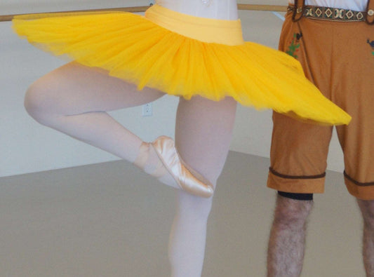 Balletttänzer trägt ein gelbes Tutu