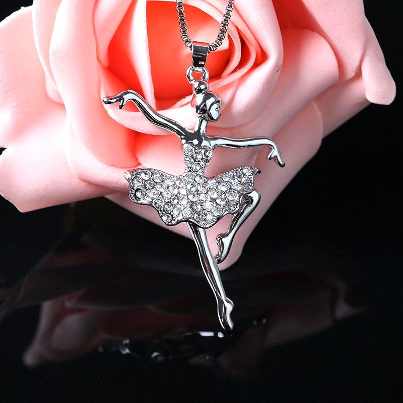 front of crystal ballerina pendant necklace in front of a rose