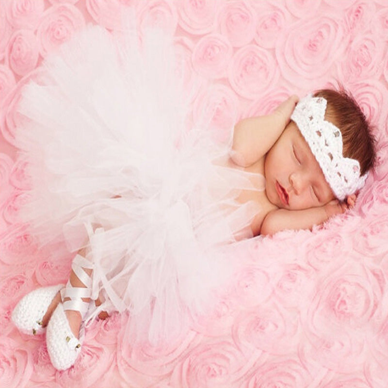 Newborn wearing a tutu, crocheted crown and crocheted ballet slippers