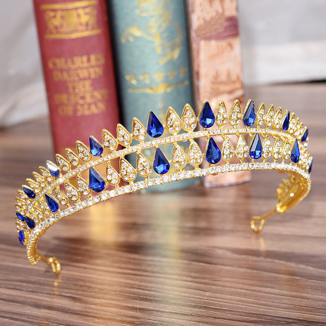 front of gold tiara with sapphire blue crystals. YAGP