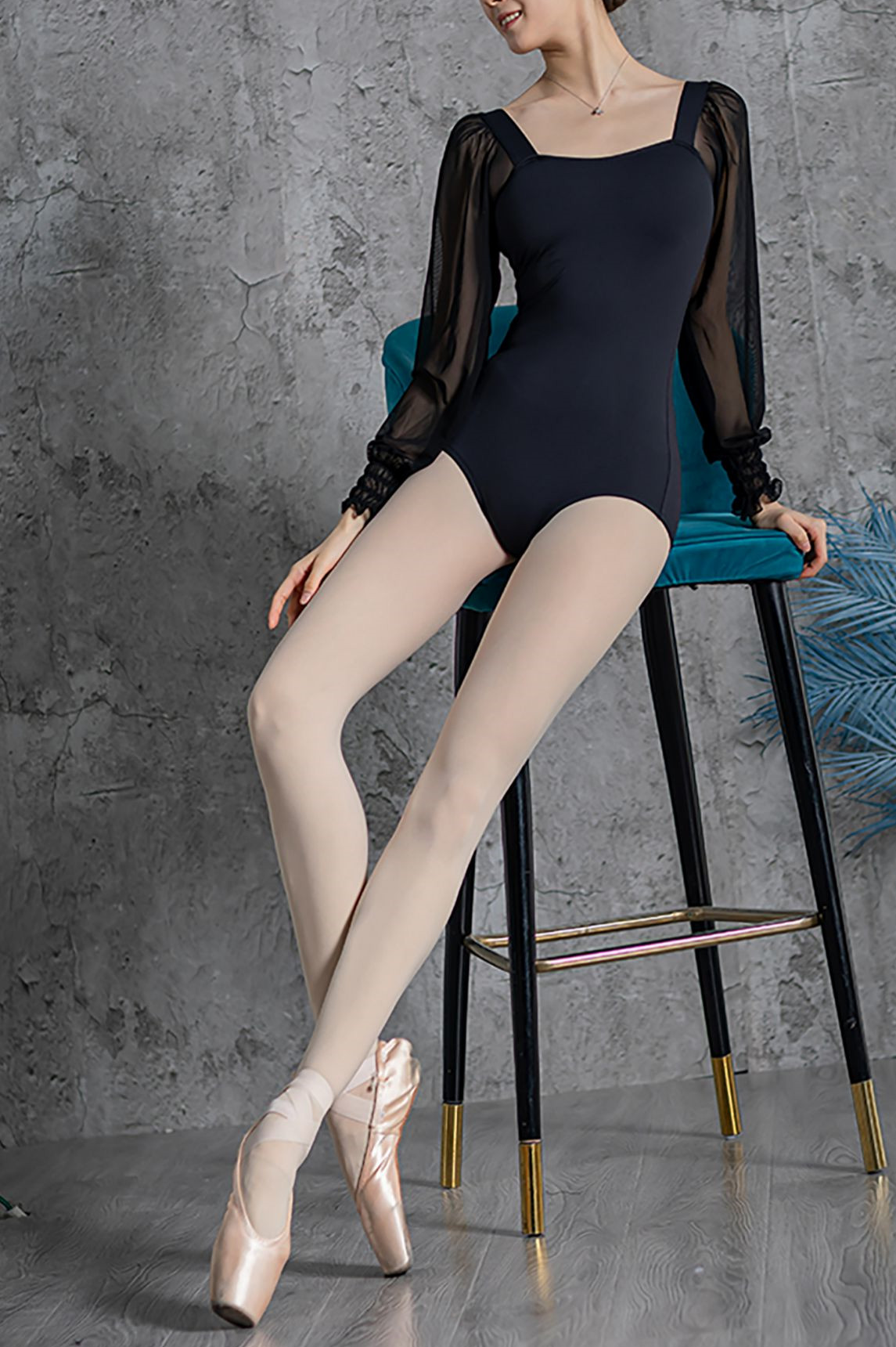 front of woman wearing black ballet leotard with sheer puffed sleeves. YAGP